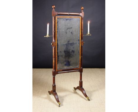 A Regency Mahogany Cheval Mirror.  The rectangular glass plate (A/F) in a cross-banded frame suspended between simulated bamb