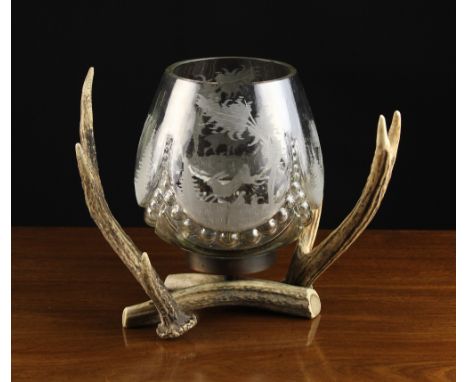 An Unusual Clear Glass Lamp mounted on a base of antlers. The lobed ovoid shade centred by a candle spike and engraved with s
