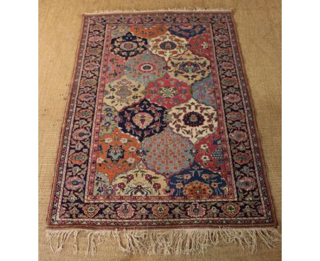 A Tabriz Carpet, Circa 1915. The centre field composed of interlocking ogee panels of dark blue, mid blue, salmon, dark pink,