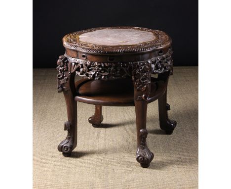 A Chinese Carved Hardwood Stand.  The petal-edged top having a pink marble insert in a border of carved prunus blossom and ro