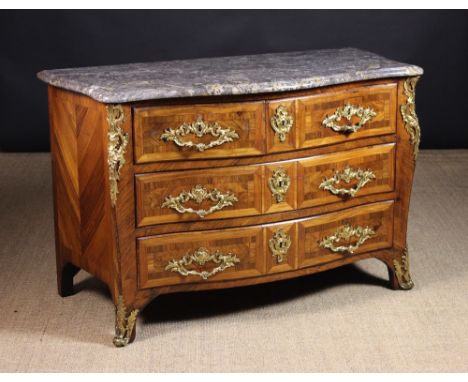 A Louis XV Serpentine Marble Topped Commode.  The chest housing two upper drawers; one being wider to accommodate the central