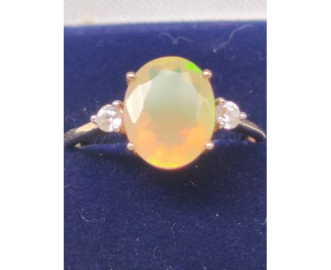 10ct yellow gold ladies ring set with a single Ethiopian opal off set by white stones to each shoulder. [Ring size P] [1.85Gr