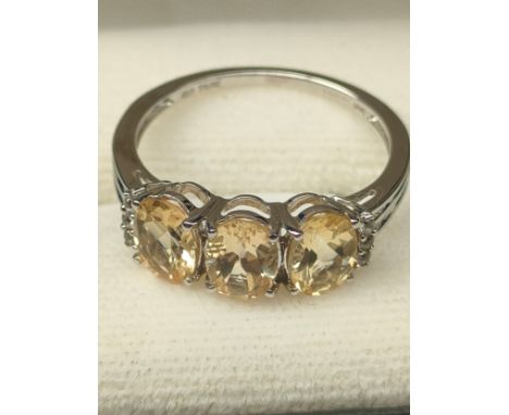 10ct white gold ladies ring set with three pale yellow gem stones off set by white stone shoulders. [Ring size Q] [2.65Grams]