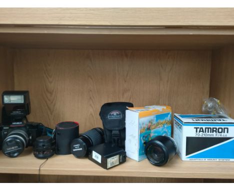 A Shelf of camera accessories includes Minolta camera &amp;  Tamron lens 