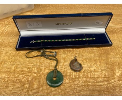 A 900 grade silver green stone setting tennis bracelet, a jade pendant and a fossil pendant 