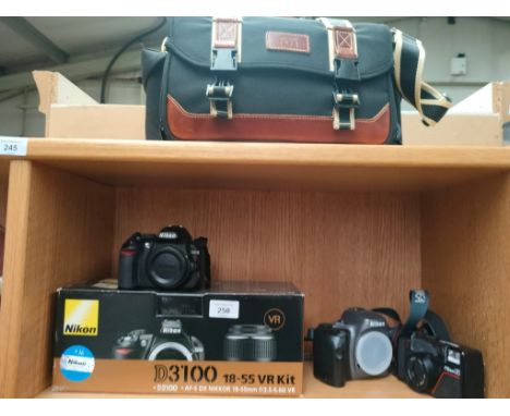 A Shelf of cameras which includes nikon d3100 camera along with jessops bag 