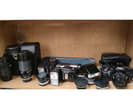 A Shelf of camera items to include minolta camera &amp; a large selection of various lenses and flashes 