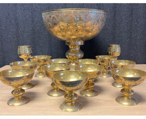 A Large ornate Indian gilt brass and enamel punch bowl, ladle and goblets. 