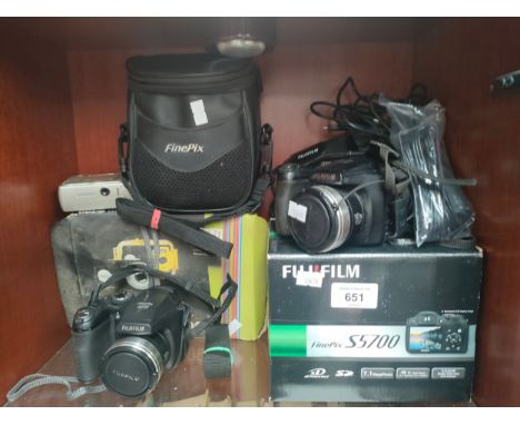 A small shelf of cameras to include fujifilm digital cameras and a waterproof boxed digital camera 