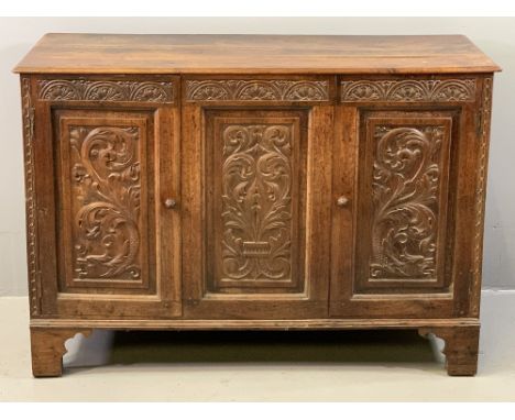 ANTIQUE CARVED OAK TWO DOOR SIDEBOARD (ex-coffer), the moulded edge top over a central panel and flanking cupboard doors, hav