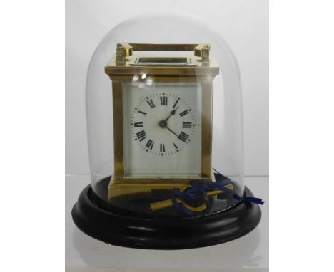 An Antique Brass Carriage Clock. The carriage clock having white enamel face, original key, under glass dome, approx 8 x 6.5 