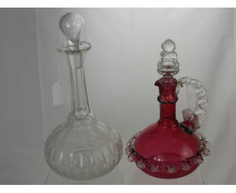 A Cranberry Decanter with shell design frill around the middle dating from the 19th Century, together with another cut glass 
