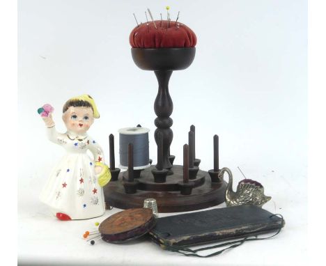 An Arts &amp; Crafts copper pin cushion of circular form together with a mahogany pin cushions and stand, a figural ceramic s
