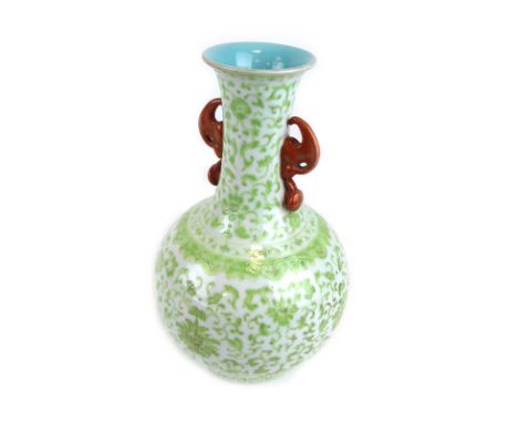 A Chinese two handled vase of elongated globular form decorated in pale green enamel with flowerheads and scrolls on a white 