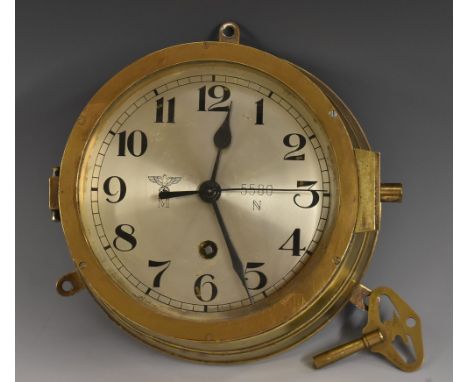 A World War II German Nazi Third Reich Kriegsmarine brass bulkhead timepiece, 14.5cm silvered clock dial inscribed with Arabi