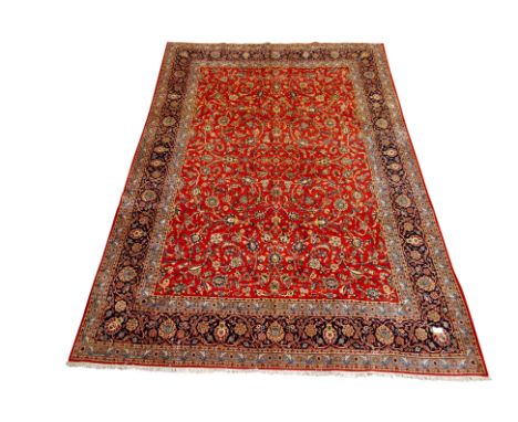 Persian Kashan red ground rug carpet, trailing floral field, multiple blue borders with stylised flower head motifs, 415cm x 