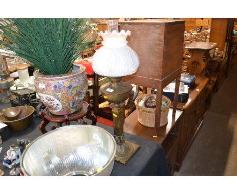 A brass oil lamp with floral decorated shade 