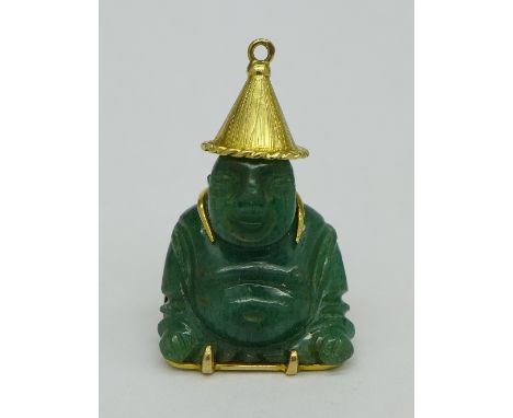 A jade Buddha set in a yellow metal oriental mount