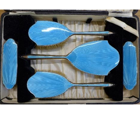 A cased silver and blue enamel dressing table set and three hair slides