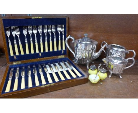 A set of plated desert knives and forks in an oak case, a three piece plated tea service, a/f, and a cruet set