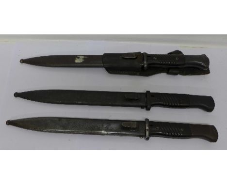 Three bayonets with scabbards; one also with frog, one with blade marked Dürkopp, one with blade and scabbard marked Mundlos 