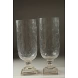 A PAIR OF CUT GLASS HURRICANE LAMPS on square stepped bases.