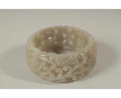 A CHINESE PIERCED JADE BANGLE. 7cms diameter x 3cms deep.