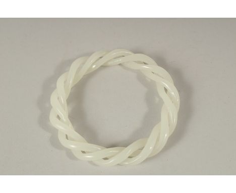 A CHINESE WHITE TWIST JADE BANGLE. 8.5cms diameter.