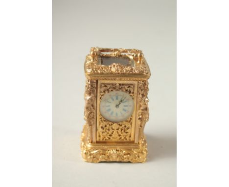 A CAST GILT MINIATURE CARRIAGE CLOCK with female figures.