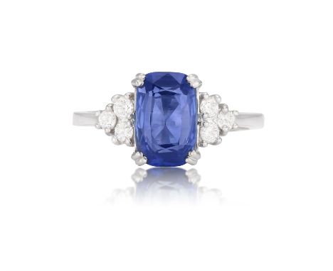 A SAPPHIRE AND DIAMOND DRESS RINGThe elongated cushion-shaped sapphire weighing approximately 2.50cts within a double four-cl