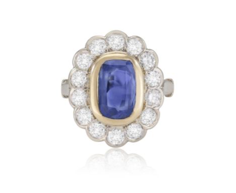 A SAPPHIRE AND DIAMOND CLUSTER RINGThe oval-shaped sapphire within collet setting to a brilliant-cut diamond surround, diamon