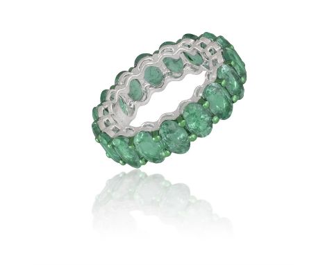 AN EMERALD ETERNITY RINGThe continuous row of oval-shaped emeralds within claw setting, mounted in 18K gold, numbered, ring s