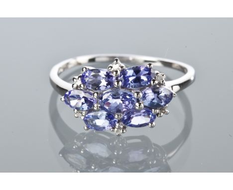 TANZANITE AND DIAMOND CLUSTER RING
set with oval cut tanzanites totalling approximately 1.70 carats, surrounded by six small 