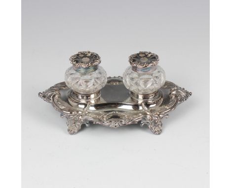 A Victorian silver desk stand, Henry Wilkinson & Co, London 1892, the oval desk stand with scroll detail and two vacant carto