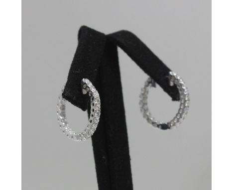 A pair of 18ct white gold diamond hinged hoop earrings, the front set with twelve round cut diamonds, and interior reverse se