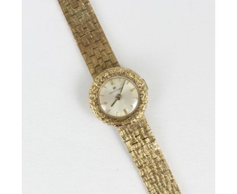 A 9ct yellow gold Hamilton ladies wristwatch, the cream coloured circular dial with baton markers, set to a textured raised c