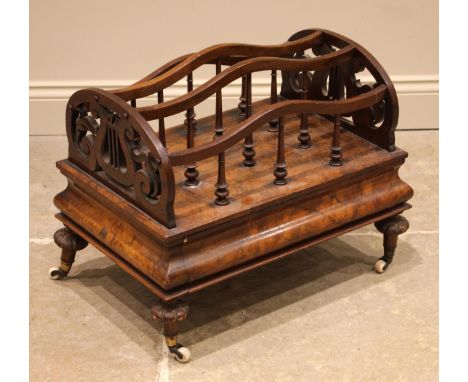 A Victorian figured walnut Canterbury, the arched dividers extending to lyre fretwork ends, upon a cushion shaped plinth base