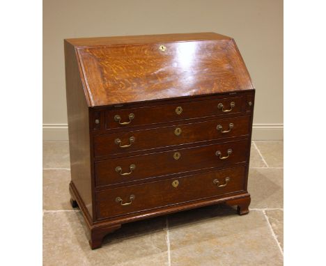 A George III oak bureau, the fall front opening to a compartmented interior with star inlay, over four graduated and cock-bea