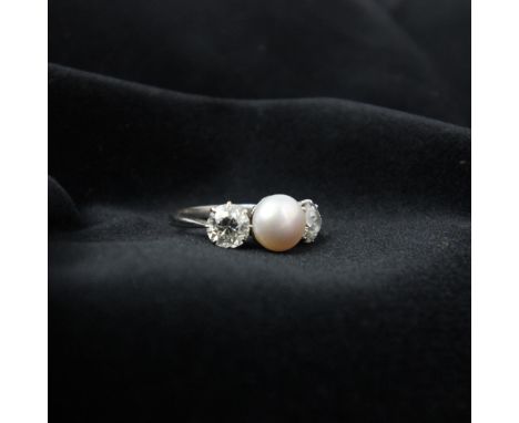 An early 20th century diamond and untested pearl ring, the central button shaped untested pearl with old cut diamond to each 