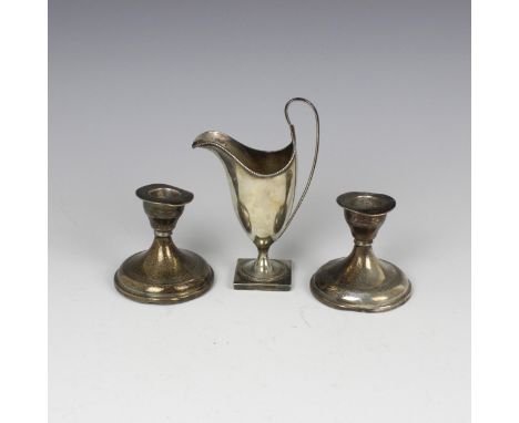 An Edwardian silver cream jug, indistinct makers mark, Birmingham 1909, the beaded rim above a plain polished helmet form bod