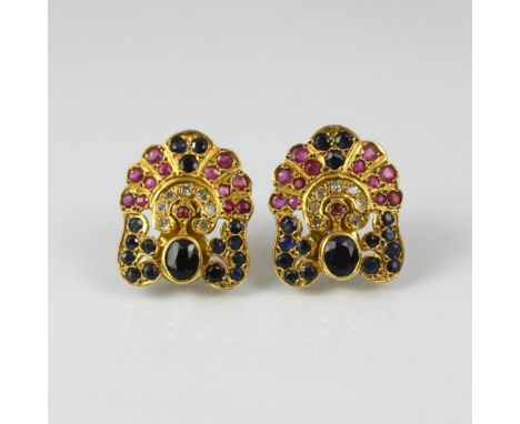 A pair of yellow metal ruby, sapphire and diamond dress earrings, possibly Thai, the central oval cut sapphire with diamond s