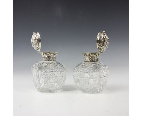 A pair of Victorian silver mounted dressing table jars, William Comyns & Sons, London 1892, the hinged embossed covers with d