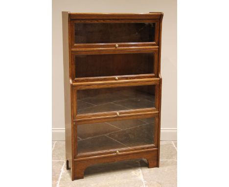 An early 20th century glazed oak four tier bookcase, each of the four graduated tiers with an 'up and over' glazed door appli