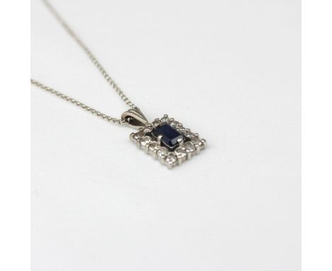 A sapphire and diamond cluster pendant, the mixed cut sapphire within openwork surround and border of fourteen round cut diam