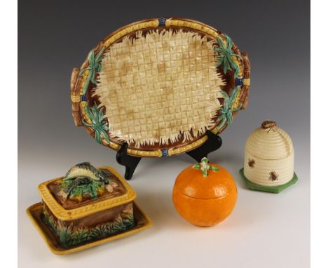 A continental majolica sardine dish and cover, 19th century, the body with integral stand, the cover with handle modelled as 