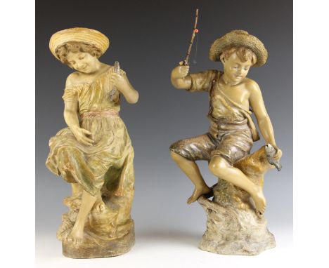 A pair of Goldscheider cold painted terracotta figures, early 20th century, modelled as a boy and girl seated on rocks fishin
