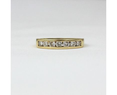 An 18ct yellow gold diamond half eternity, the seven round cut diamonds channel set in yellow gold, leading to plain polished