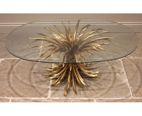 A Hollywood Regency gilt metal coffee/centre table, mid 20th century, the bevelled oval glass top upon a gilt metal pedestal 