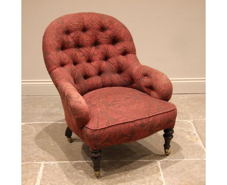 A Victorian tub chair, in burgundy foliate fabric, the arched button back extending to down swept arms over the sprung serpen