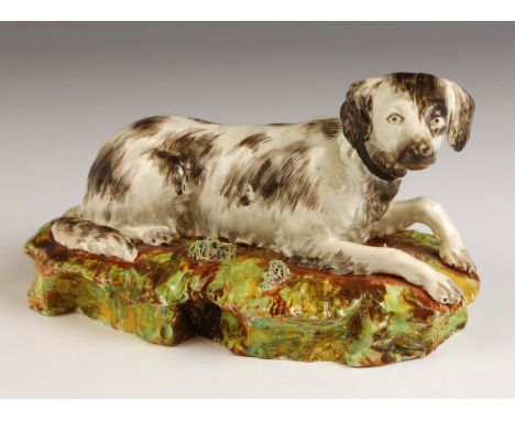 A Staffordshire pearlware pottery spaniel dog, probably by Enoch Wood works, or Neale & Co, circa 1820, modelled recumbent on
